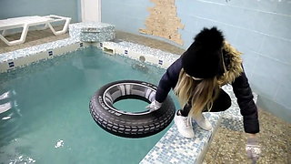 wetlook girl with winter clothes swims in the pool