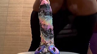Busty ebony slut stains the camera squirting as she rides a dildo