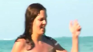 Horny brunette babe flashing a hairy pussy on the beach
