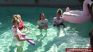 Four girls are enjoying stripping in the swimming pool, with one lucky guy joining them