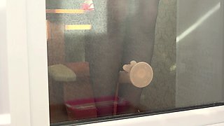 A neighbor observes thru the window, as a COUGAR ravages herself with a faux-cock by the balcony door. Cool arse in rear end-fashion.