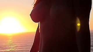 Buxom babe shows off sexy body in nude poses at sunset