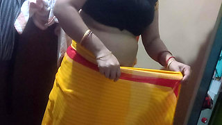 Indian housewife is wearing a yellow saree.