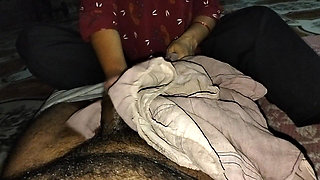 A desi wife massaging her husband's member with oil using her soft hands at night.