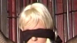 Mature Dominatrix Oversees Masked Man with Bound Blonde