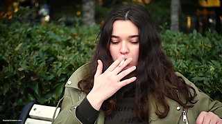 Young Brunette Is Taking an Unhurried Stroll with Allwhite 120mm Cigarette