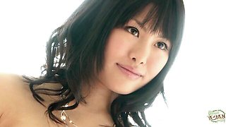 Asian nude on brown leather couch gives oral still holding notebook and blue pen