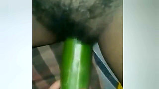 A Young Woman Is Inserting a Cucumber Into Her Pussy